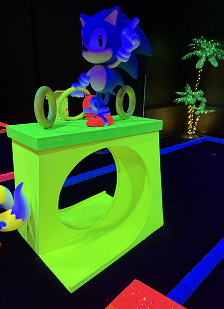 Parcours de mini-golf intérieur rétro éclairé en lumière noire, décor fluorescent